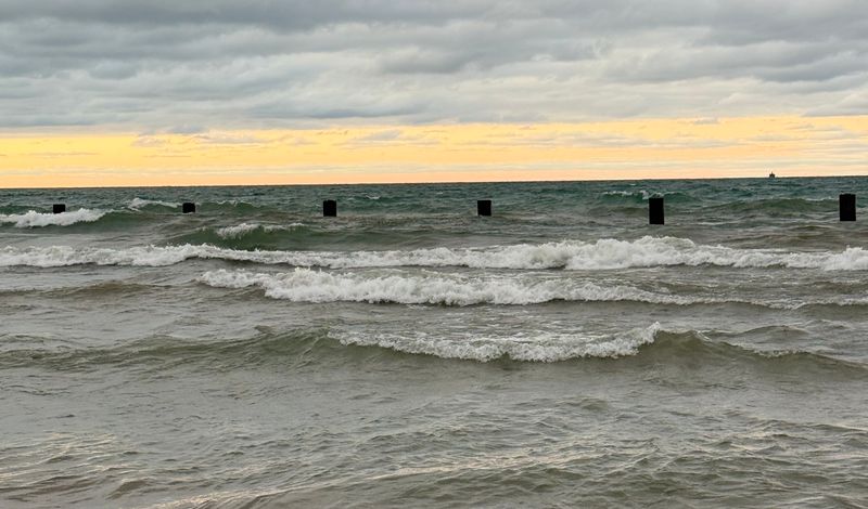 Captivating view of Lake Michigan waves against a dramatic sunrise sky.